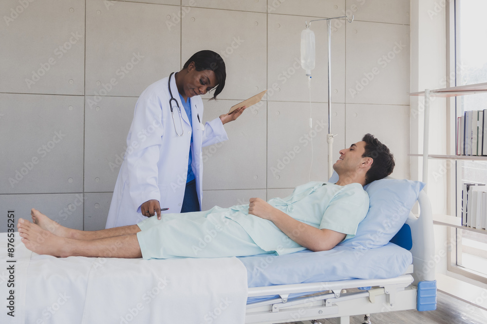 Obraz premium Patient caucasian man lying bed with woman doctor black people stand carer physical therapist two person talk help support and check treat sick person take care of your health in room hospital clinic
