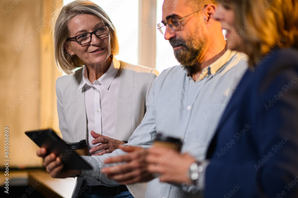 Mature businesspeople with tablet cooperating and working on project. Mature businesspeople with tablet cooperating and working on project.