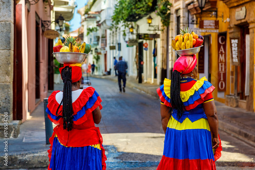Two Palenquera women walk the streets of the walled city to take photos with tourists