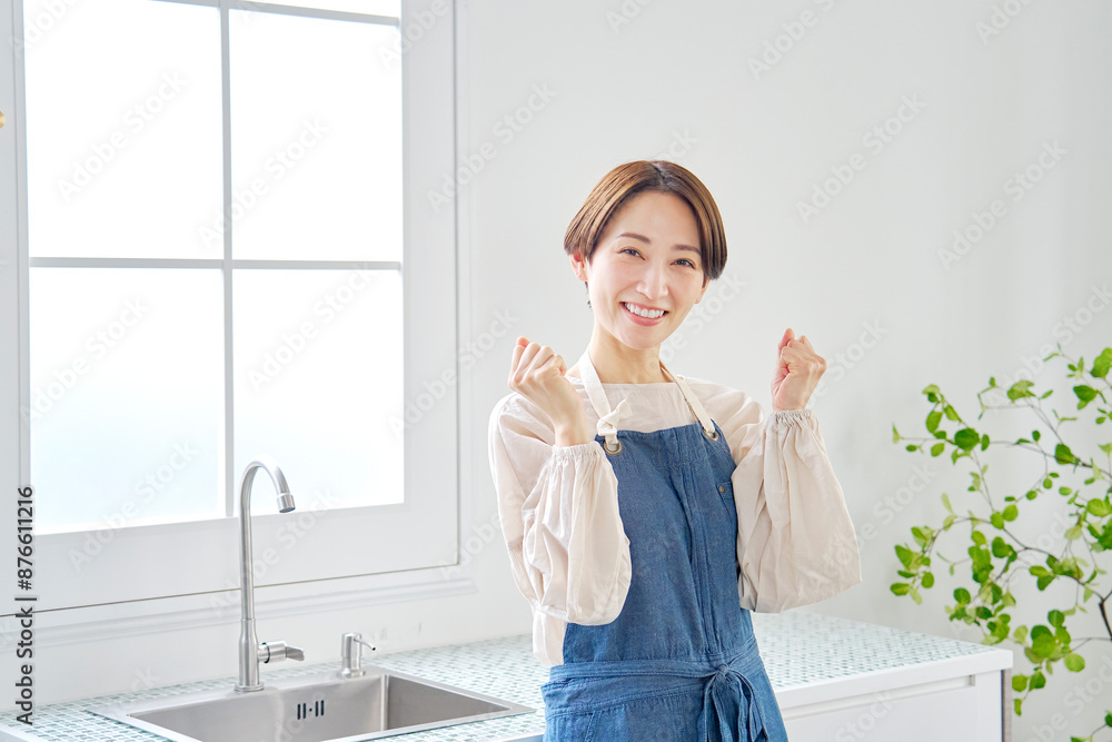 キッチンでガッツポーズするハ女性 キッチンでガッツポーズするハ女性