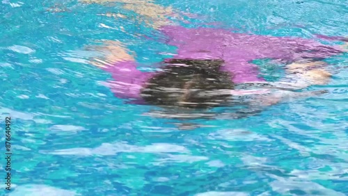 Child dives and swims underwater in the pool