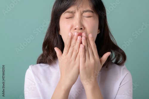 sneeze flu problem. Allergic Asian woman sneezing on green background