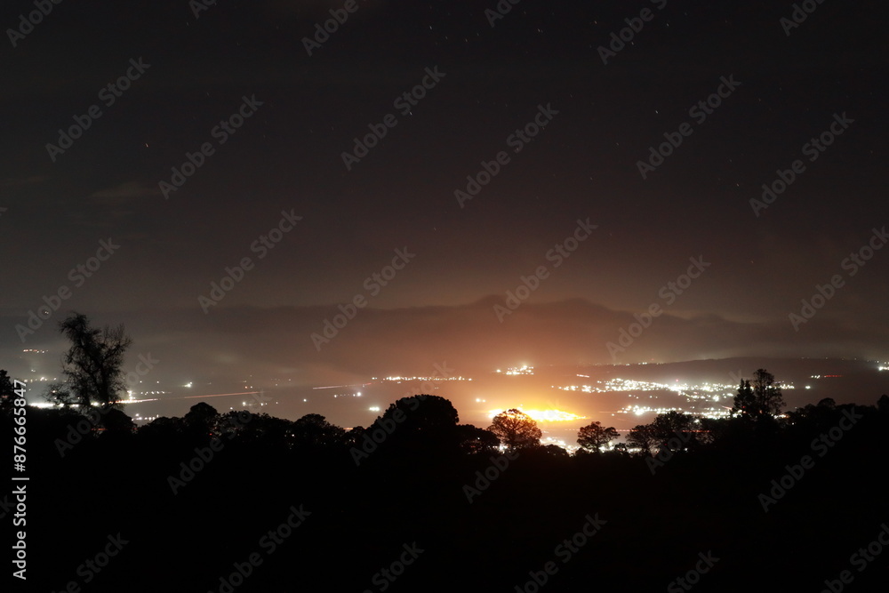 Nighttime Cityscape Illuminated from Mountain View with Starry Night Sky Nighttime Cityscape Illuminated from Mountain View with Starry Night Sky