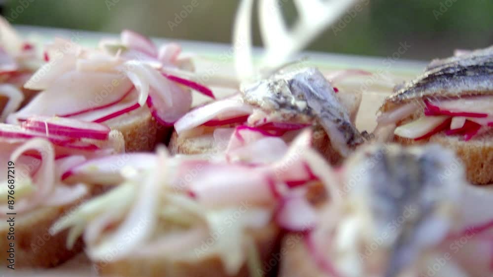 Close-up of a chef using a spatula to arrange gourmet toasts topped with grilled fish and fresh radish slices. The scene emphasizes precision, culinary creativity, and the art of food presentation. Close-up of a chef using a spatula to arrange gourmet toasts topped with grilled fish and fresh radish slices. The scene emphasizes precision, culinary creativity, and the art of food presentation.
