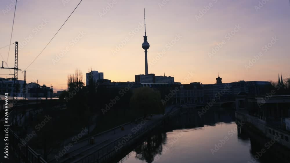 Driving with train over a river bridge in Berlin, Germany at sunset with view on television tower copy space, sunrise, fernsehturm Driving with train over a river bridge in Berlin, Germany at sunset with view on television tower copy space, sunrise, fernsehturm