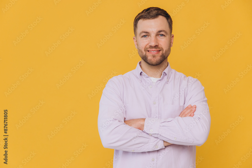 Cute unshaven man smiling with healthy teeth and crossed arms in purple shirt posing isolated on yellow background with copy space Cute unshaven man smiling with healthy teeth and crossed arms in purple shirt posing isolated on yellow background with copy space