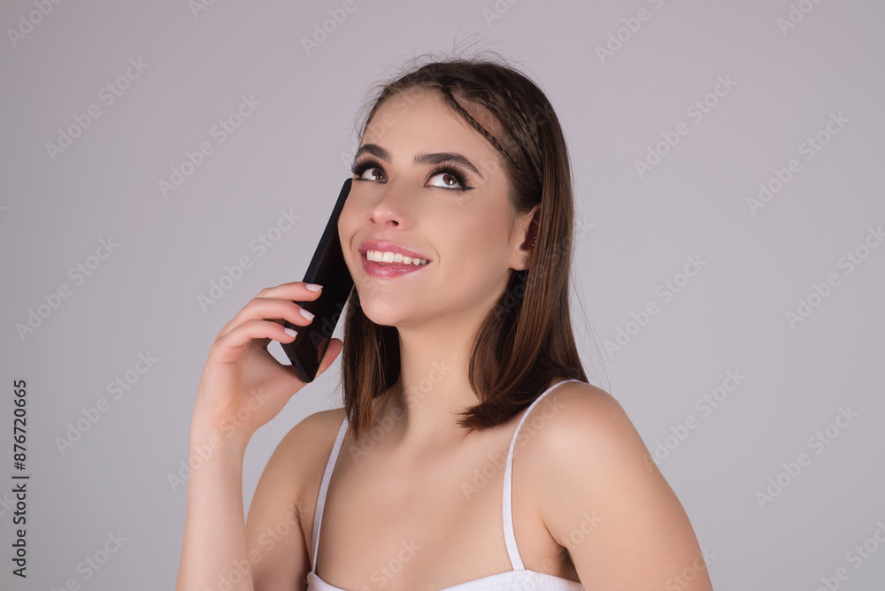 Young woman using phone device gadget app isolated over studio background. Girl holding a smartphone, chatting by mobile phone. Girl using phone, studio portrait. Woman makes telephone call on phone. Young woman using phone device gadget app isolated over studio background. Girl holding a smartphone, chatting by mobile phone. Girl using phone, studio portrait. Woman makes telephone call on phone.
