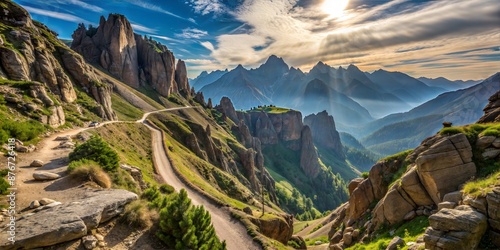 Majestic Mountain Landscape with Winding Path and Rocky Peaks Under Sunlit Sky