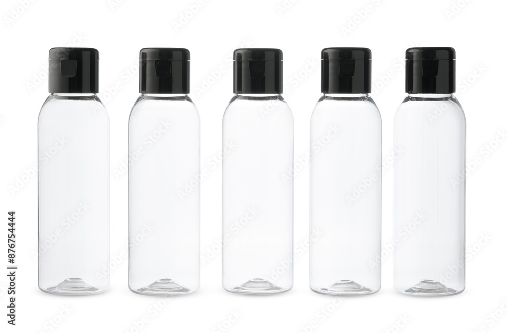 Five Clear Plastic Bottles With Black Caps on a White Background Five Clear Plastic Bottles With Black Caps on a White Background