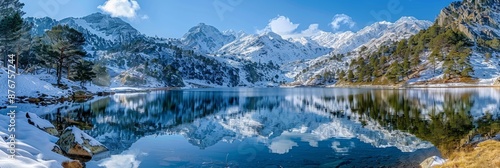 Reflection of the snowy mountains in the beautiful Baciver lake in the Pyrenees mountains of Val dAran Aran Valley. Lleida. Catalonia. Spain