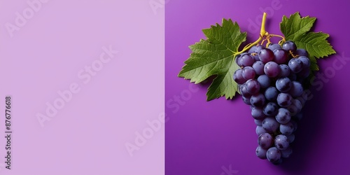 Fresh purple grapes with green leaves on purple background. Copy space, flat lay. For use in food photography, advertisements, and design projects that require a touch of natural beauty and freshness