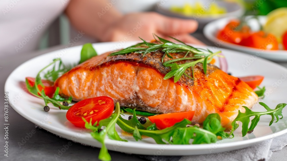 A plate of food with a piece of salmon and tomatoes on top. The plate is set on a table A plate of food with a piece of salmon and tomatoes on top. The plate is set on a table