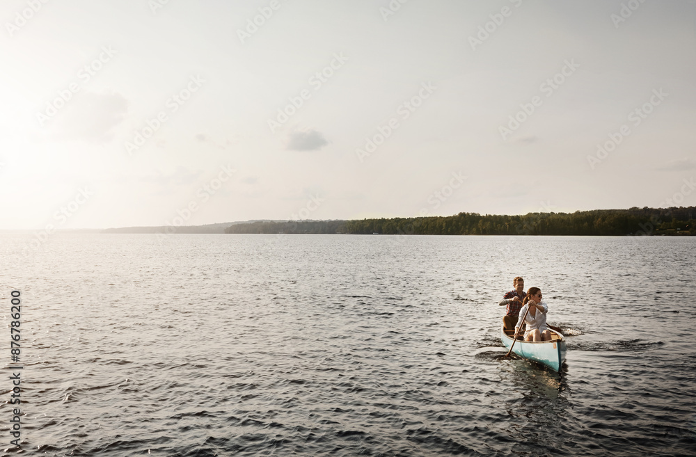 Naklejka premium Lake, water and couple in kayak in nature, fitness or transport for adventure in countryside. Paddle, sunset or remote living on island for married people, exercise or workout on river with mockup