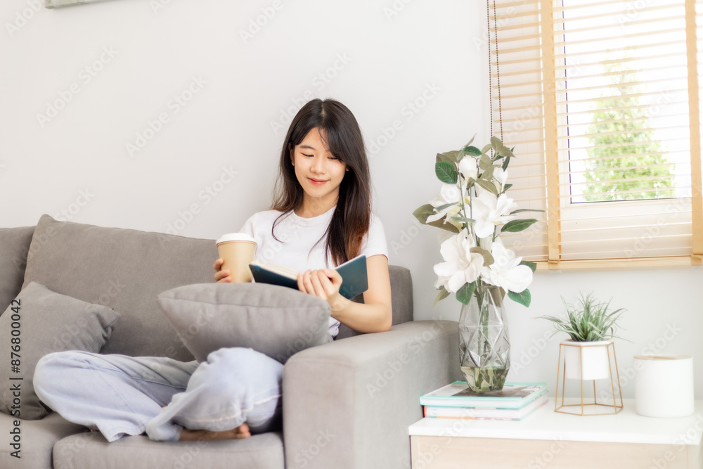 Woman sipping coffee and reading a book on the sofa. Woman sipping coffee and reading a book on the sofa.