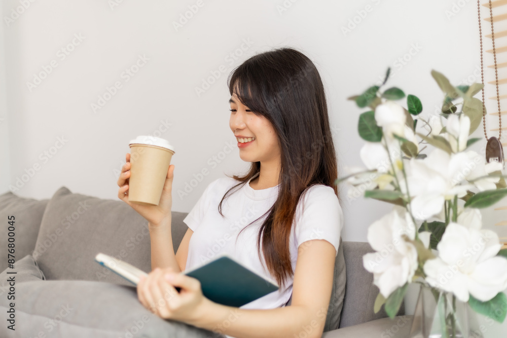 Woman sipping coffee and reading a book on the sofa. Woman sipping coffee and reading a book on the sofa.