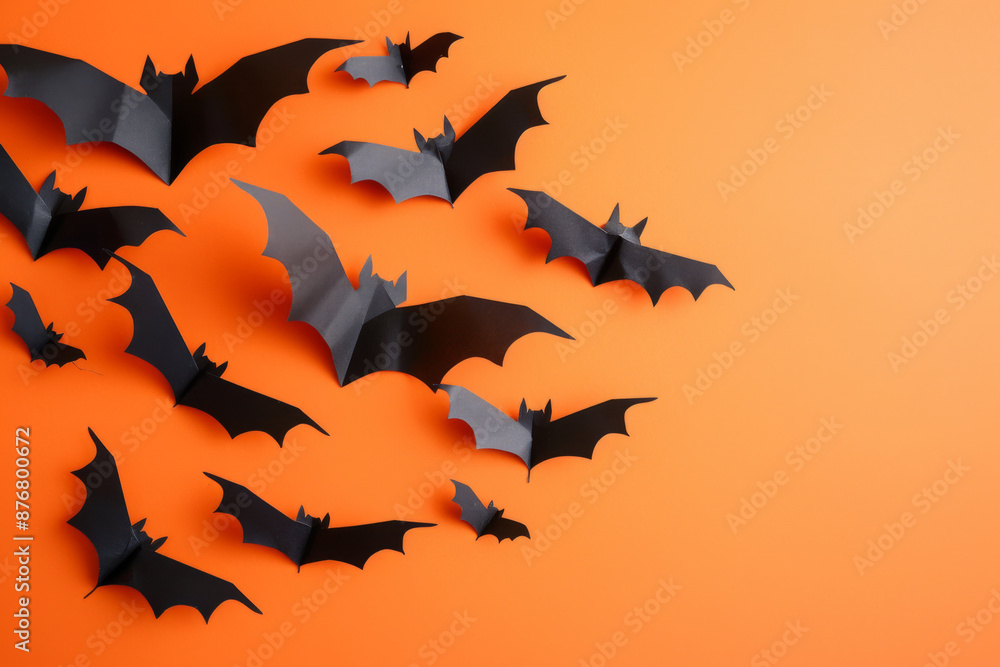 Halloween and decoration concept with paper bats flying isolated on orange background with copy space Halloween and decoration concept with paper bats flying isolated on orange background with copy space