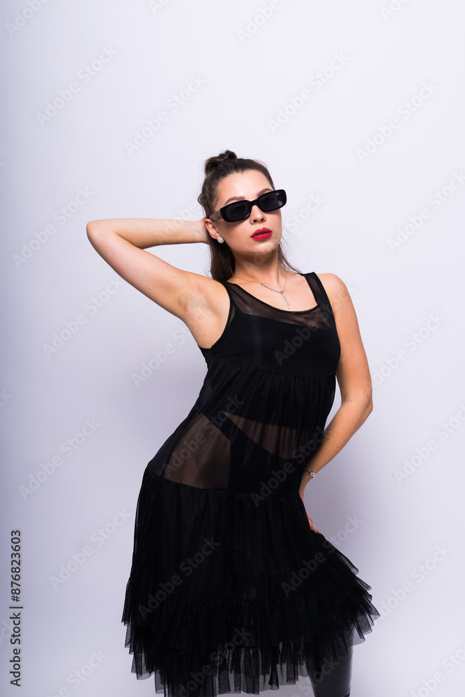 Young brunette lady in black dress posing on grey background Young brunette lady in black dress posing on grey background