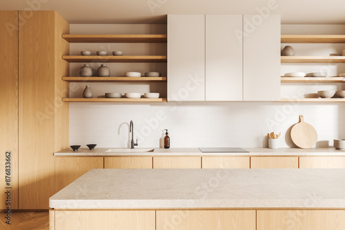 Light home kitchen interior with bar counter, sink and kitchenware with shelves