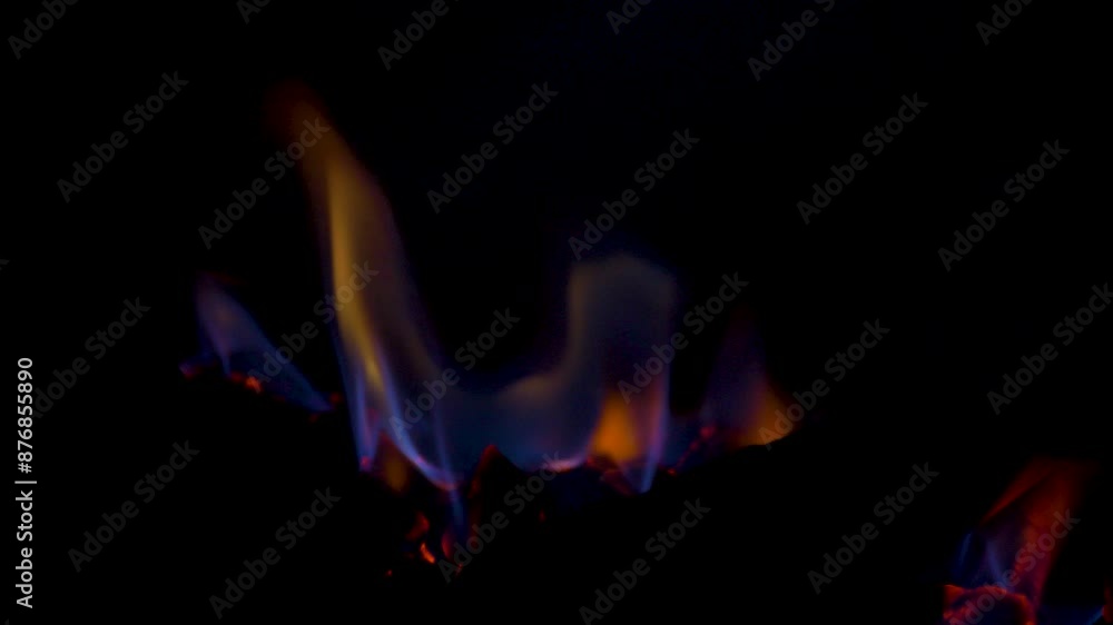 Slow motion close-up shot of gas fireplace hot flames burning embers on charcoal coal fake wooden logs behind glass panel household heating energy Slow motion close-up shot of gas fireplace hot flames burning embers on charcoal coal fake wooden logs behind glass panel household heating energy