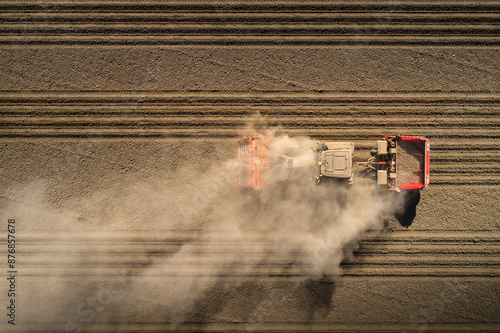 Tractor blowing dust and plowing field photo