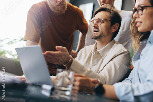 Business man showing his colleagues a slideshow presentation of his ideas on a laptop