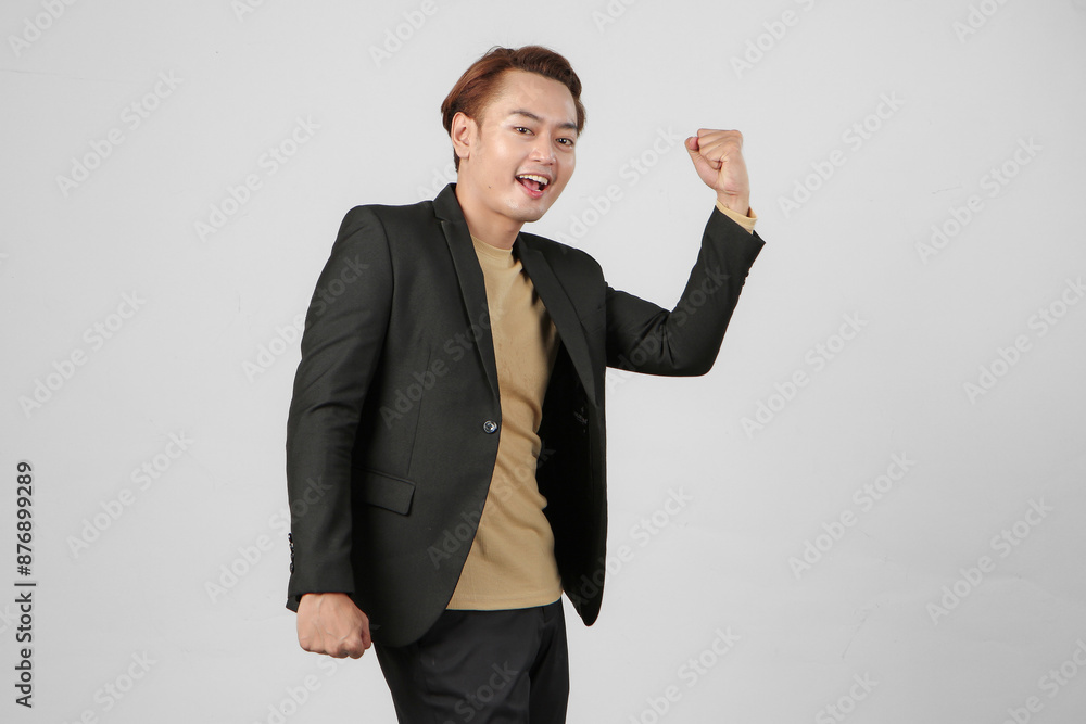 portrait of happy asian businessman wearing suit with clenched fist celebration in winning, success or promotion on isolated background portrait of happy asian businessman wearing suit with clenched fist celebration in winning, success or promotion on isolated background