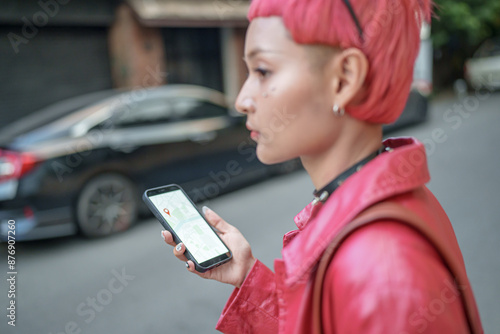 Traveler Gen z girl leather fashion with punk Asian woman tourist in city street searching location in map application online smart phone using GPS navigating