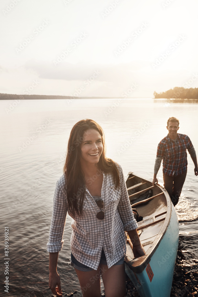 Fototapeta premium Sunset, boat and teamwork with couple in lake for adventure, summer and journey in nature. Man, woman and sunshine or wellness for travel, freedom and support or canoe in water by river or creek