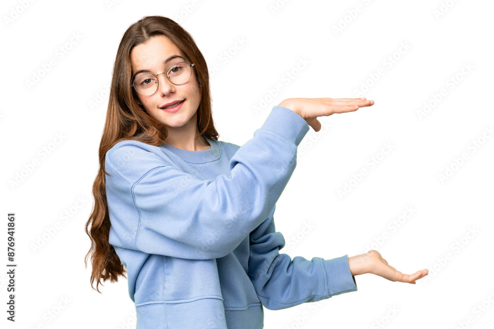 Teenager girl over isolated chroma key background holding copyspace to insert an ad Teenager girl over isolated chroma key background holding copyspace to insert an ad