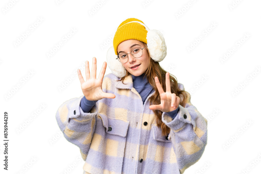 Teenager girl wearing winter muffs over isolated chroma key background counting eight with fingers Teenager girl wearing winter muffs over isolated chroma key background counting eight with fingers