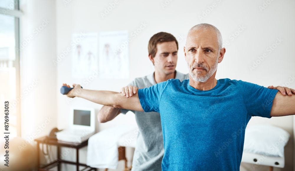 Obraz premium Recovery, physiotherapist and mature man with dumbbell in clinic for physical therapy, support or mobility exercise. Health, male doctor and patient for help, muscle injury or rehabilitation