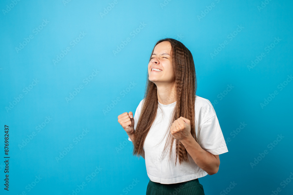 Teenager portrait on blue background, joyful, showing success with her hands,young cute emotional student, attractive female, happy teen posing Teenager portrait on blue background, joyful, showing success with her hands,young cute emotional student, attractive female, happy teen posing
