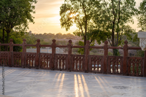 Early morning dawn dusk sunlight filtering through railing on walkway with trees showing rajput architecture in rajasthan photo