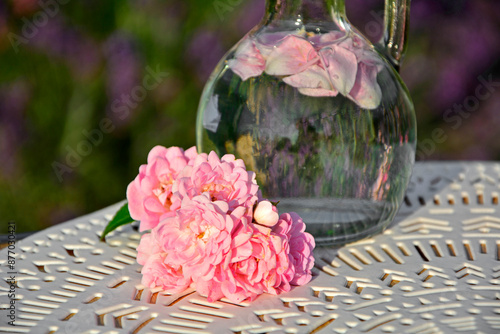 Obraz na płótnie woda różana w szkalnej butelce z korkiem, woda aromatyzowana płatkami róży w butelce, rose water in a glass bottle, water flavored with rose petals in a bottle, Rose water in a glass bottle w salonie