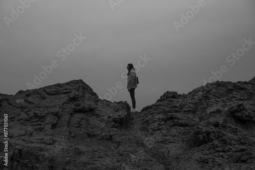 Lone figure stands atop rocky landscape near Favaritx Lighthouse