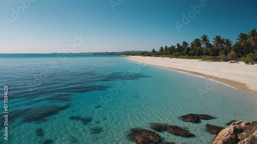 Fototapeta Naklejka Na Ścianę i Meble -  A beautiful beach on a sunny day with crystal clear blue sea and a cloudless sky
