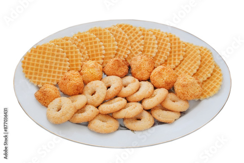 Variety of cakes and waffles in ceramic plate isolated on a white background. Golden romantic biscuit. Top view.