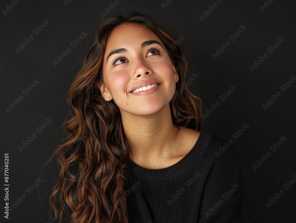 A happy woman looks up at the clear blue sky with a smile on her face A happy woman looks up at the clear blue sky with a smile on her face