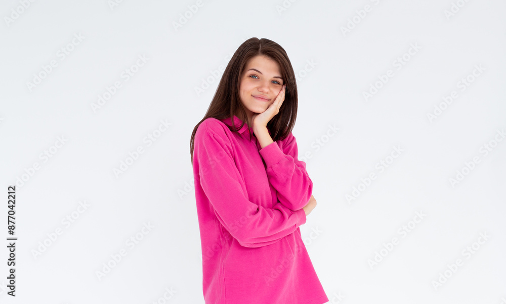 Portrait of young stylish girl smiling with hand on cheek looking at camera. Copy space. Isolated on white Portrait of young stylish girl smiling with hand on cheek looking at camera. Copy space. Isolated on white