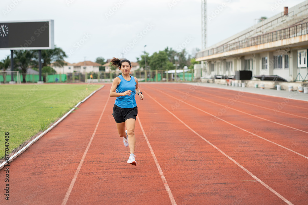 Asia mature woman runner training on racetrack and field Asia mature woman runner training on racetrack and field