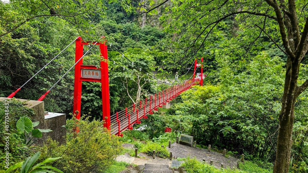 Scenic view of a Danlan Suspension Bridge amidst lush green forest and hills Scenic view of a Danlan Suspension Bridge amidst lush green forest and hills