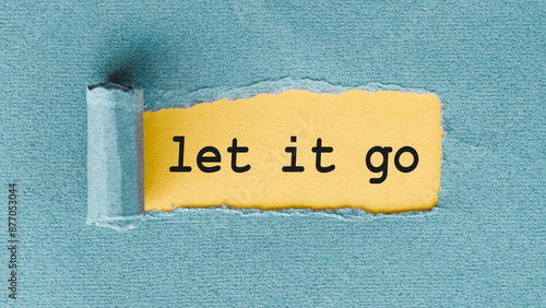 Obraz na płótnie A yellow piece of paper with the phrase Let It Go written on it has been torn from a blue sheet of paper, leaving a jagged edge