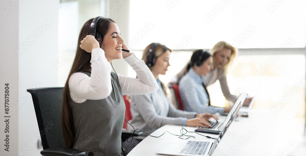Female call center operator putting on her wireless headset and preparing for work. Female call center operator putting on her wireless headset and preparing for work.