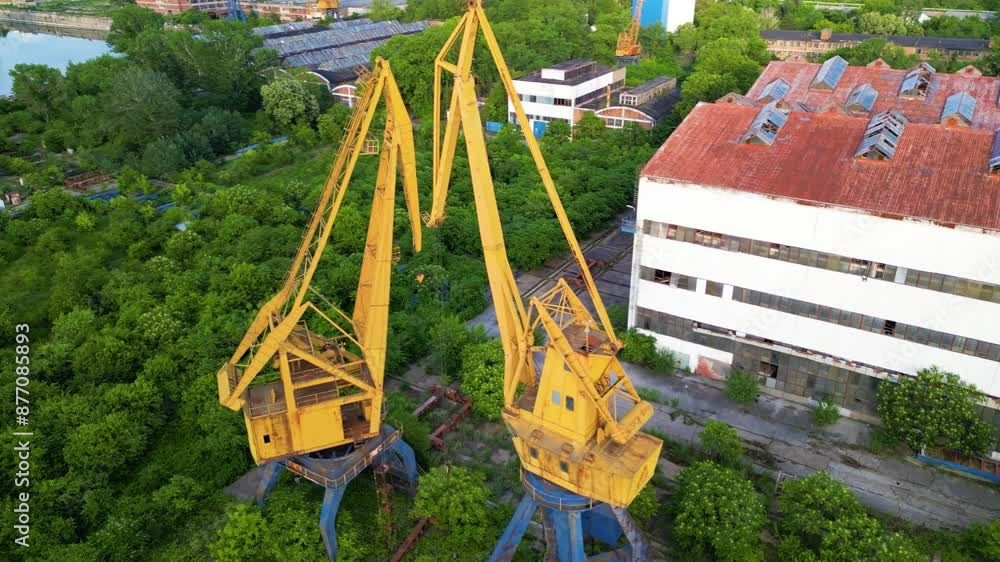 Dilapidated abandoned port cranes, dry dock and infrastructure at the Danube river port of Ruse in Bulgaria. Drone shot of graving dock with ship to shore cranes on the bank of a river. STS crane.
Dilapidated abandoned port cranes, dry dock and infrastructure at the Danube river port of Ruse in Bulgaria. Drone shot of graving dock with ship to shore cranes on the bank of a river. STS crane.