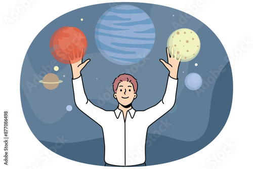 Man stands among planets of space and enjoys virtual reality technology that allows to travel around galaxy. Guy who loves space explores universe thanks to digital planetarium with VR