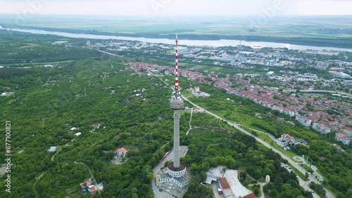 Aerial drone footage of a super tall free standing structure for mobile, radio and tv transmittion and broadcast. Concrete tower in Ruse, Bulgaria with sky view restorant. Sunset footage of skyscraper photo