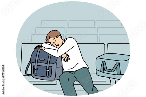 Sleeping man sits in lounge area at airport and waits for arrival of plane delayed due to bad weather. Tired guy airport passenger with bags and luggage waiting for flight and travel