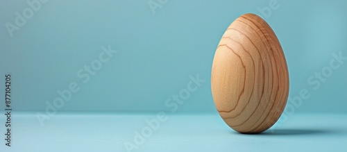 Handcrafted wooden egg for art on a blue background symbolizing Easter, creativity, and handcrafting, displayed in a side view with copy space image. photo