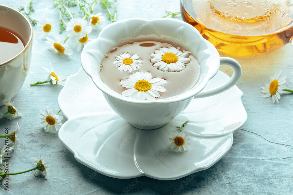 Chamomile flower tea. A tea cup and a tea pot with fresh medicinal flowers, natural organic remedy. Healthy drink, healing and soothing, with fresh blossoms Chamomile flower tea. A tea cup and a tea pot with fresh medicinal flowers, natural organic remedy. Healthy drink, healing and soothing, with fresh blossoms
