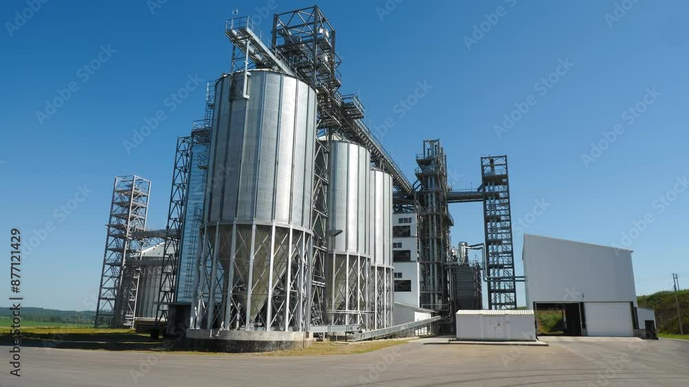 large modern grain elevator in field on sunny summer day, metal tanks for grain large modern grain elevator in field on sunny summer day, metal tanks for grain